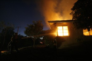A firefighter sprays water on a house burning during the Jesusita fire in Santa Barbara